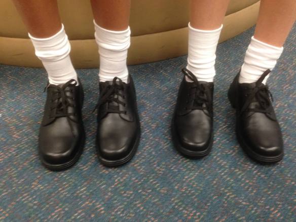 Two girls in boring black laceup school shoes